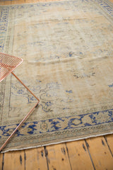 Distressed Oushak rug with worn pile texture showing pale sand and dusty blue.
