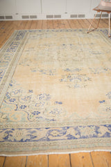Distressed vintage Oushak carpet with foundation wear, muted blue and seafoam motifs.