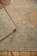 Distressed vintage Oushak carpet texture showing even wear, apricot, blue, green hues.