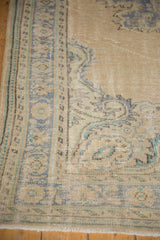 Distressed Oushak carpet corner with faded beige, dusty blue, and mint green Rococo border.