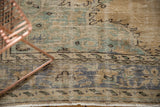 Hand-knotted vintage distressed Oushak rug edge in sand, mint green, and charcoal patterns.