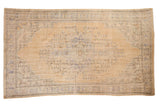 Decorative distressed Oushak carpet, faded beige field with pale blue medallion, 6' x 10'1