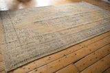 Distressed Oushak rug showing worn pile, faint foundation, pale blue and green motifs.