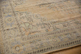 Worn beige Oushak rug border, with pale blue and seafoam green geometric patterns.