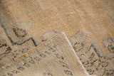 Distressed Oushak rug, showing texture of worn pile and hand-knotted reverse.