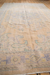 Textured distressed Oushak rug section with faded blue and mint green boteh paisley.
