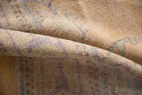 Evenly worn pile of a distressed Oushak rug, showing faded beige, blue, and mint.