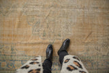 Vintage distressed Oushak carpet, mostly even wear with visible foundation, faded gold and muted blue.