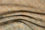 Distressed Oushak carpet showing worn, textured pile in beige, dusty gold, and mint green.