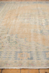 Distressed Oushak rug pile with visible wear to foundation, knot heads, and short fringe.