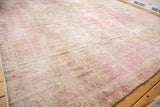 Distressed vintage Sivas carpet surface showing faded fuchsia blossoms and low pile.