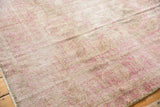Distressed vintage Sivas carpet surface with faded curvilinear pink florals and beige tones.
