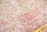 Distressed Sivas carpet showing wear to foundation, faded fuchsia floral vinery.