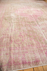 Distressed vintage Sivas rug texture with faded pink patterns and olive gold tones.
