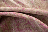 Folded vintage Sivas carpet, showing distressed pile texture in dusty gold and fuchsia pink.