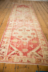 Distressed hand-knotted Oushak runner, with faded raspberry red and antique ivory motifs.