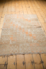 Distressed Oushak rug, tangerine and ivory lattice motif, showing low pile and subtle foundation.