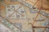 Distressed Oushak runner texture, highlighting pale gold and seafoam serrated leaf spandrels.