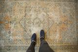 Muted orange and silver tones on the worn, geometric pile of a distressed Oushak rug.