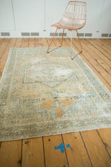 Distressed vintage Oushak rug corner, showing faded orange, silver, ivory, and visible wear.