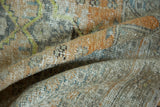 Close-up of distressed Oushak rug texture, showing worn pile in pale orange and antique ivory.