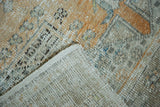 Distressed Oushak pile in faded orange, silver, ivory, revealing hand-knotted foundation.