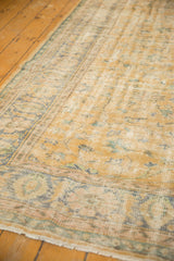 Distressed vintage Oushak rug showing mostly even wear with pale blue vinery pattern.