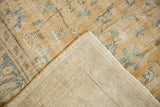 Vintage Distressed Oushak: folded corner shows pale gold pile, muted blue, woven foundation.