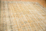 Faded pale gold, denim blue, and ivory vinery on a distressed Oushak rug.