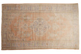 Vintage Distressed Oushak carpet, dusty apricot, scalloped blue and green floral medallion.