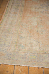 Foundation visible on distressed vintage Oushak carpet with faded apricot and blue.