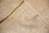 Oushak carpet back showing tight hand-knotted weave, apricot selvage, and distressed pile.