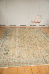 Fringed edge and even wear on a distressed Oushak rug with mint green splayed florals.