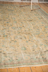 Distressed vintage Oushak rug texture with worn pile showing foundation and muted floral vinery.
