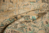 Textured pile of a distressed vintage Oushak rug showcasing splayed floral motifs in beige and mint.