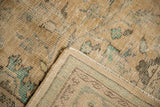 Distressed Oushak carpet pile showing worn texture, restored selvage, and woven foundation.