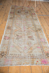 Distressed Oushak runner end, low pile, faint foundation, geometric pattern, and pink.