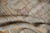 Distressed Oushak rug runner texture, showing mostly even wear with ivory, terracotta, and pink.