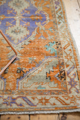 Distressed vintage Oushak rug runner showing orange, faded blue, and mint geometric patterns.