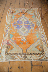 Distressed Oushak rug runner's edge, showing worn pile and geometric border.