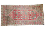 Distressed Oushak runner with a faded red diamond medallion and muted floral patterns.