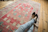 Muted coral and beige geometric border on a vintage distressed Oushak runner.