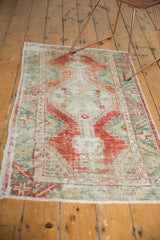 Textural distressed Oushak rug showcasing worn pile and faded rust red, seafoam green.