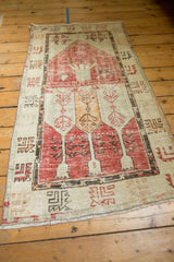 Evenly worn pale cherry red and tangerine germinating plant motifs on Oushak rug.