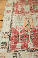 Distressed vintage Oushak runner's pale cherry red, tangerine plant motifs and alternating ivory border.