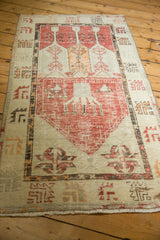 Close-up of vintage Oushak runner's distressed pile, ivory fringe, and geometric border.