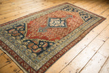 Antique Malayer rug showing dusty rust field, navy finial, germinating shrubs, faint foundation.