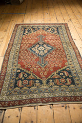 Antique Malayer rug corner, dusty rust germinating shrubs, navy spandrel, and medallion finial.