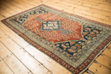 Antique Malayer rug corner, showing navy, madder root red, and beige intricate borders with even wear.