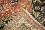 Hand-knotted beige foundation and rustic red, navy patterned pile of an antique Malayer rug.